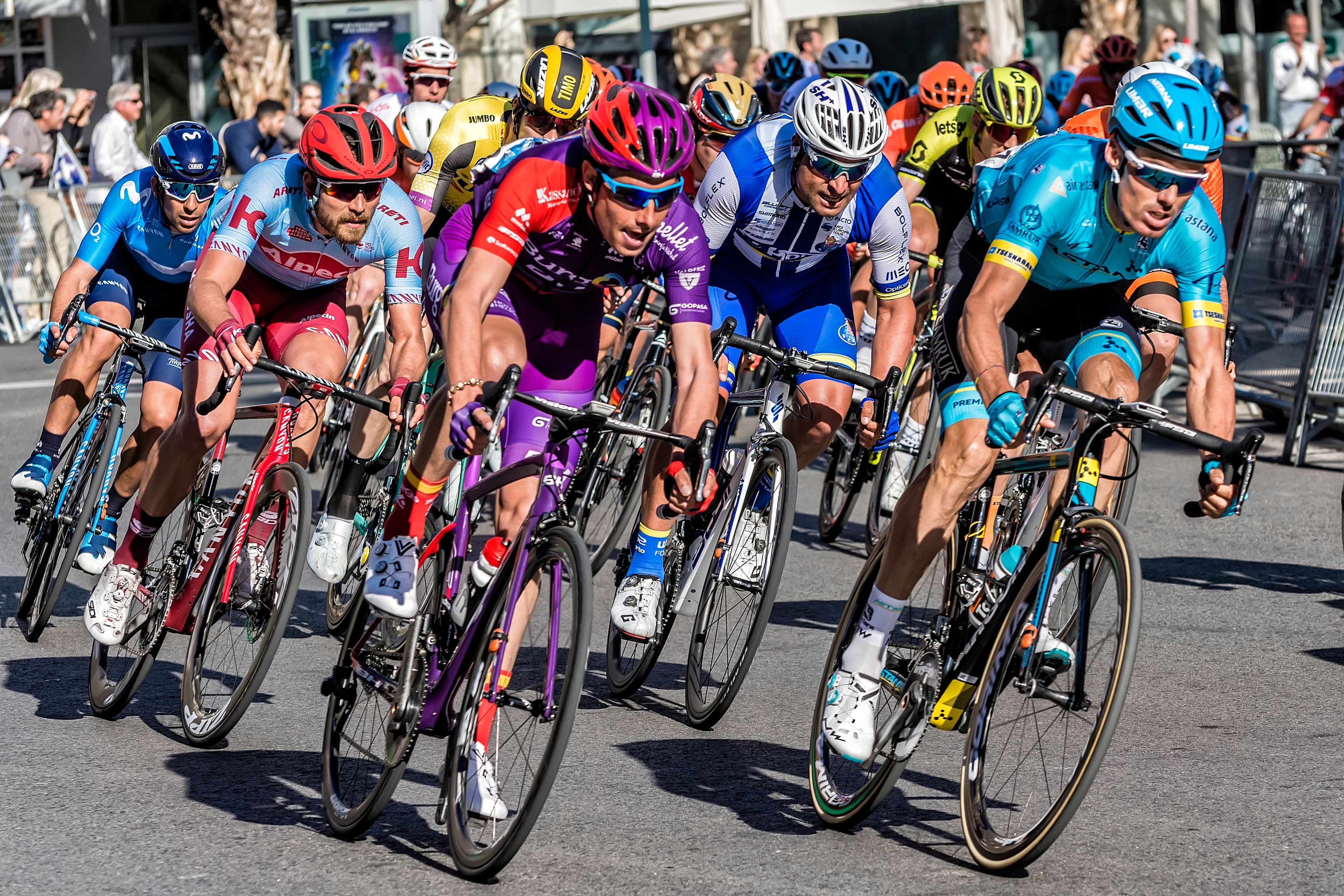 photo: pack of cyclists leaning into a bend